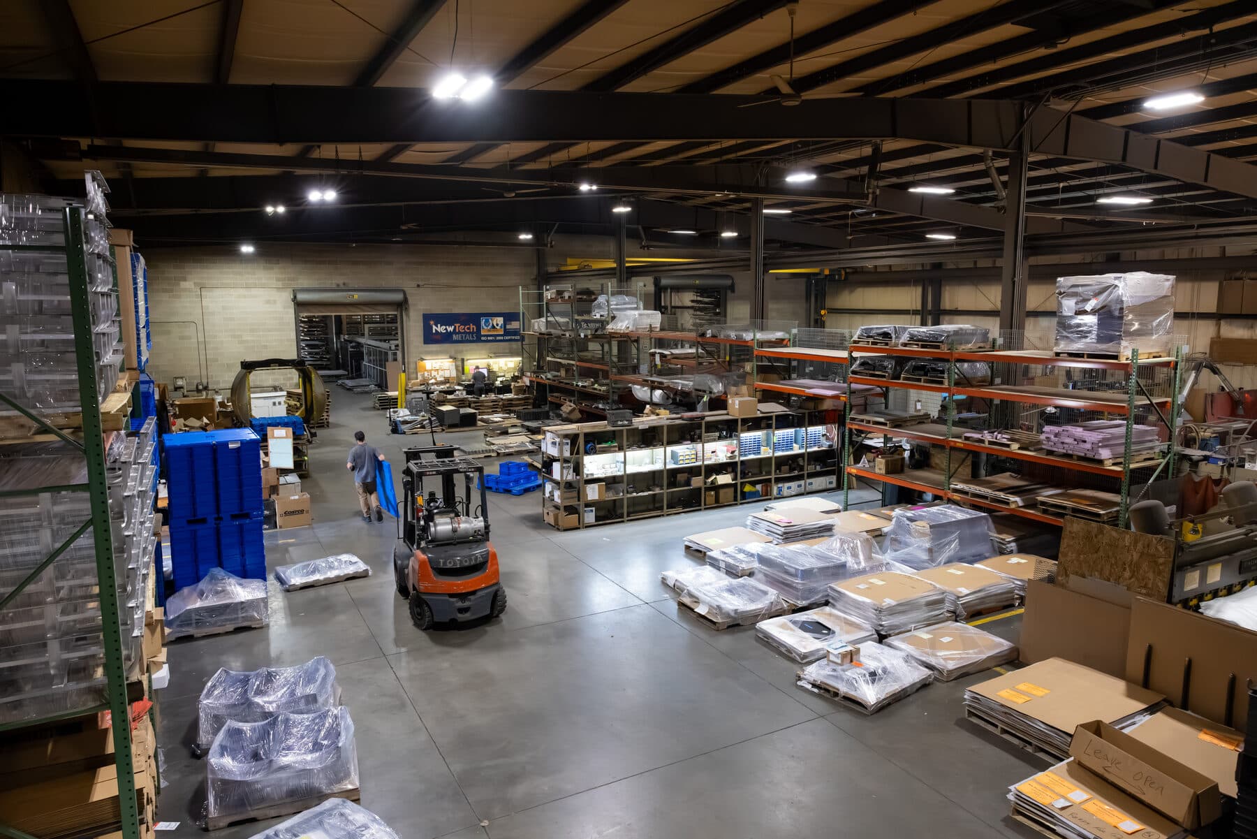 New Tech Metals warehouse: material storage racking, palletized inventory, and shipping area with a forklift